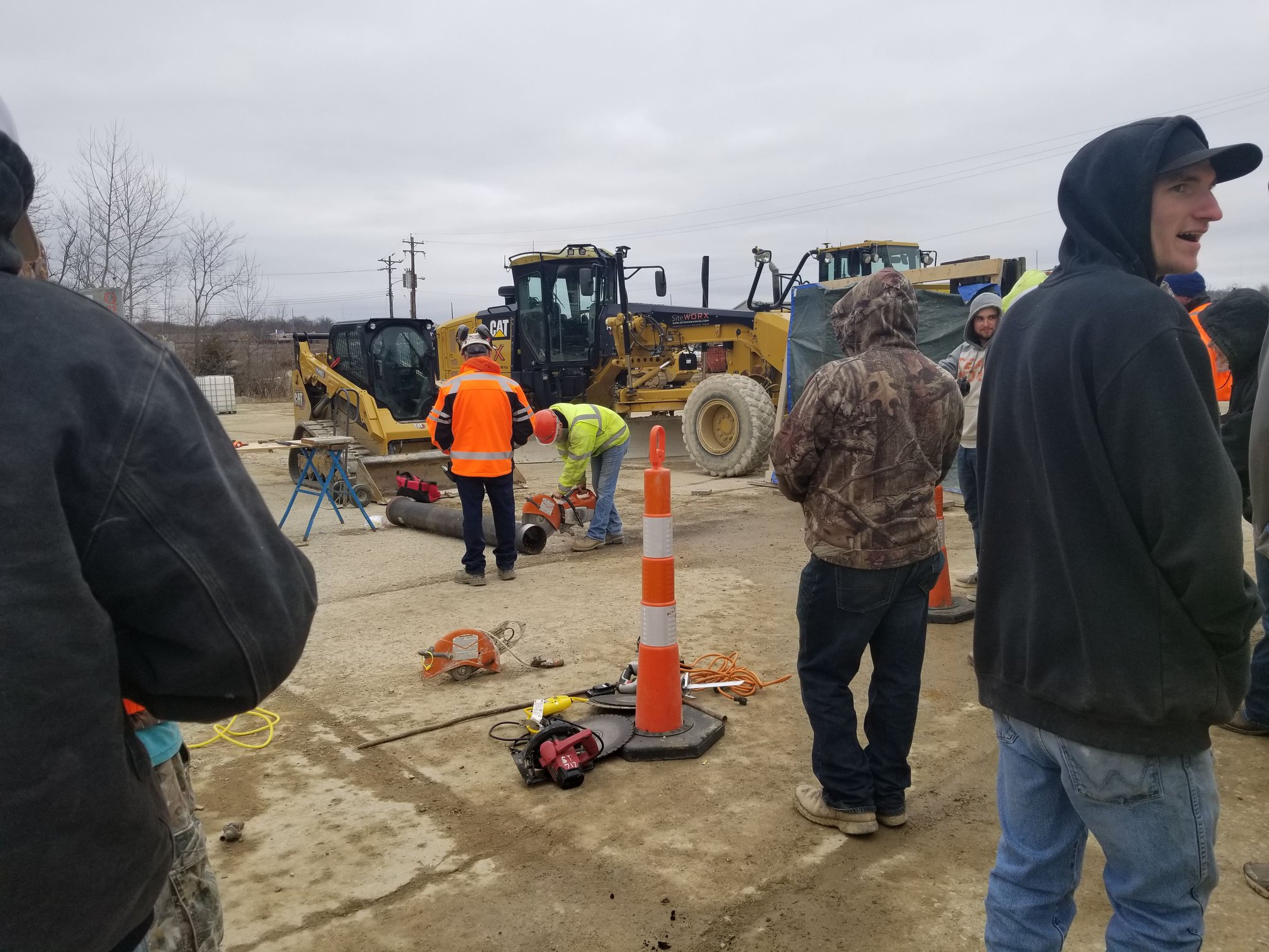 construction workers sawing a pole